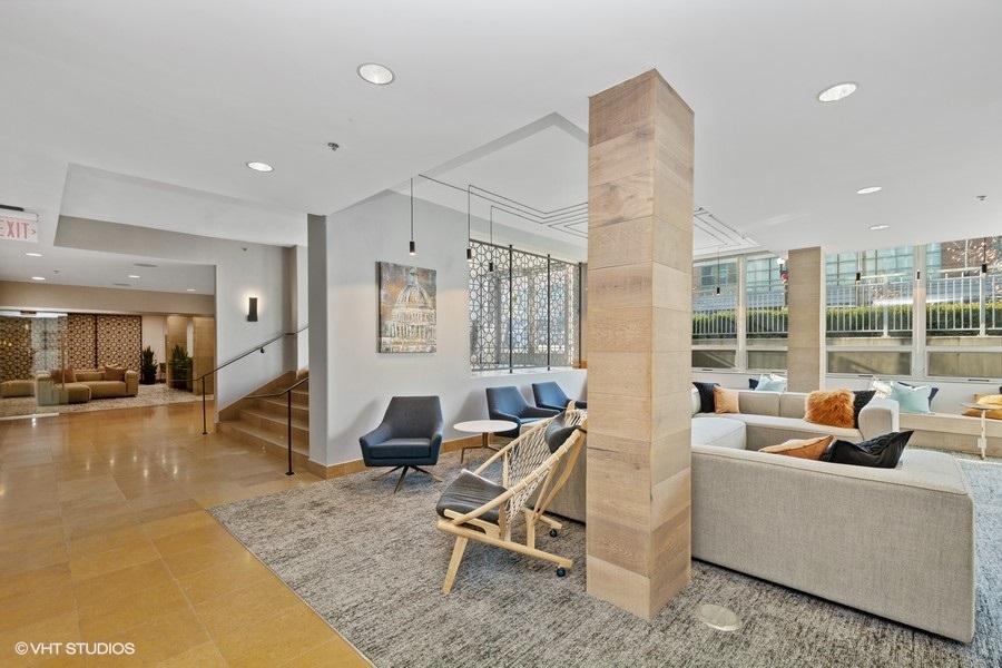 a living room with couches and chairs and a staircase